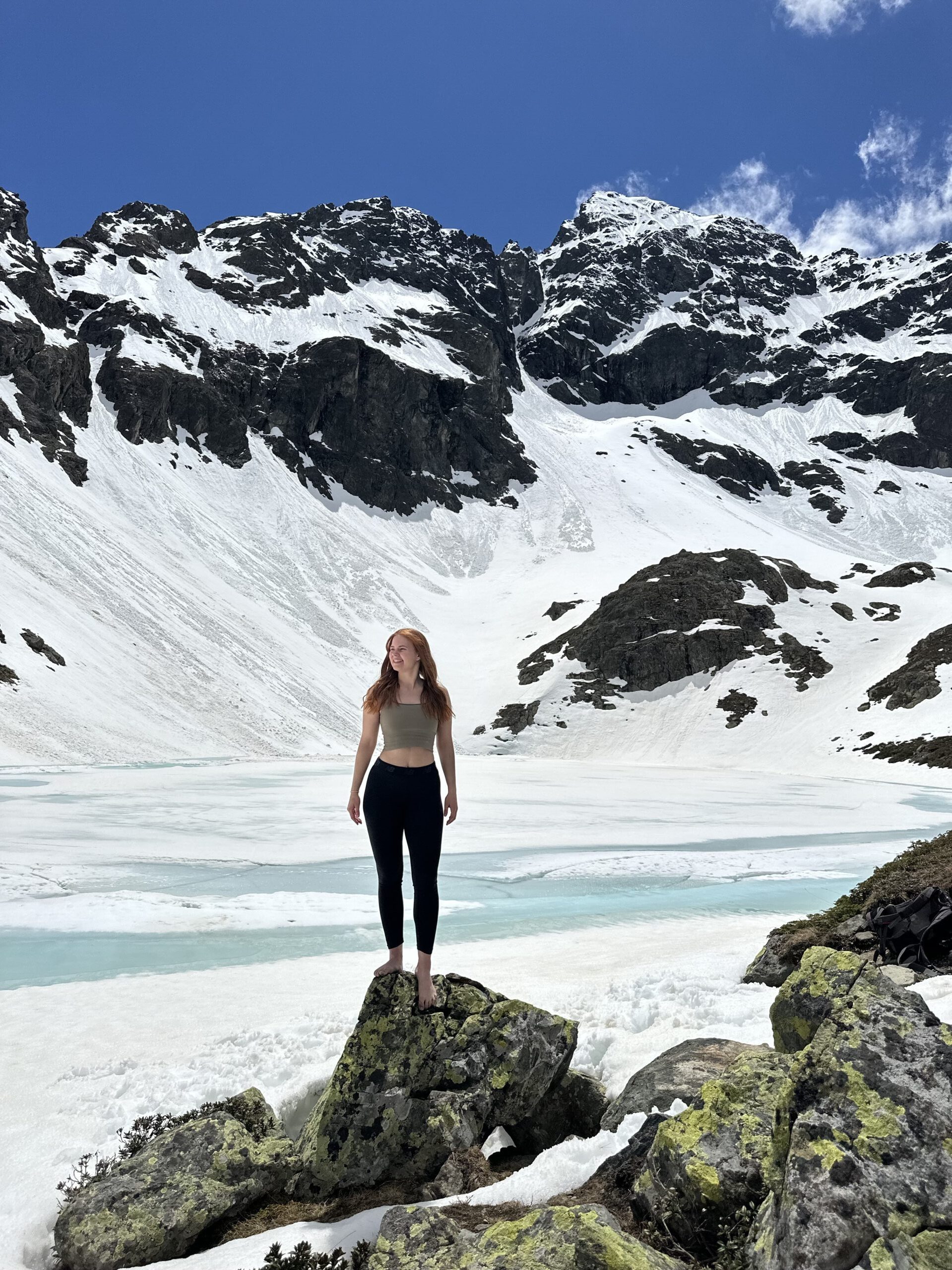 Eine Yogini, die sich in einer winterlichen Landschaft befindet.