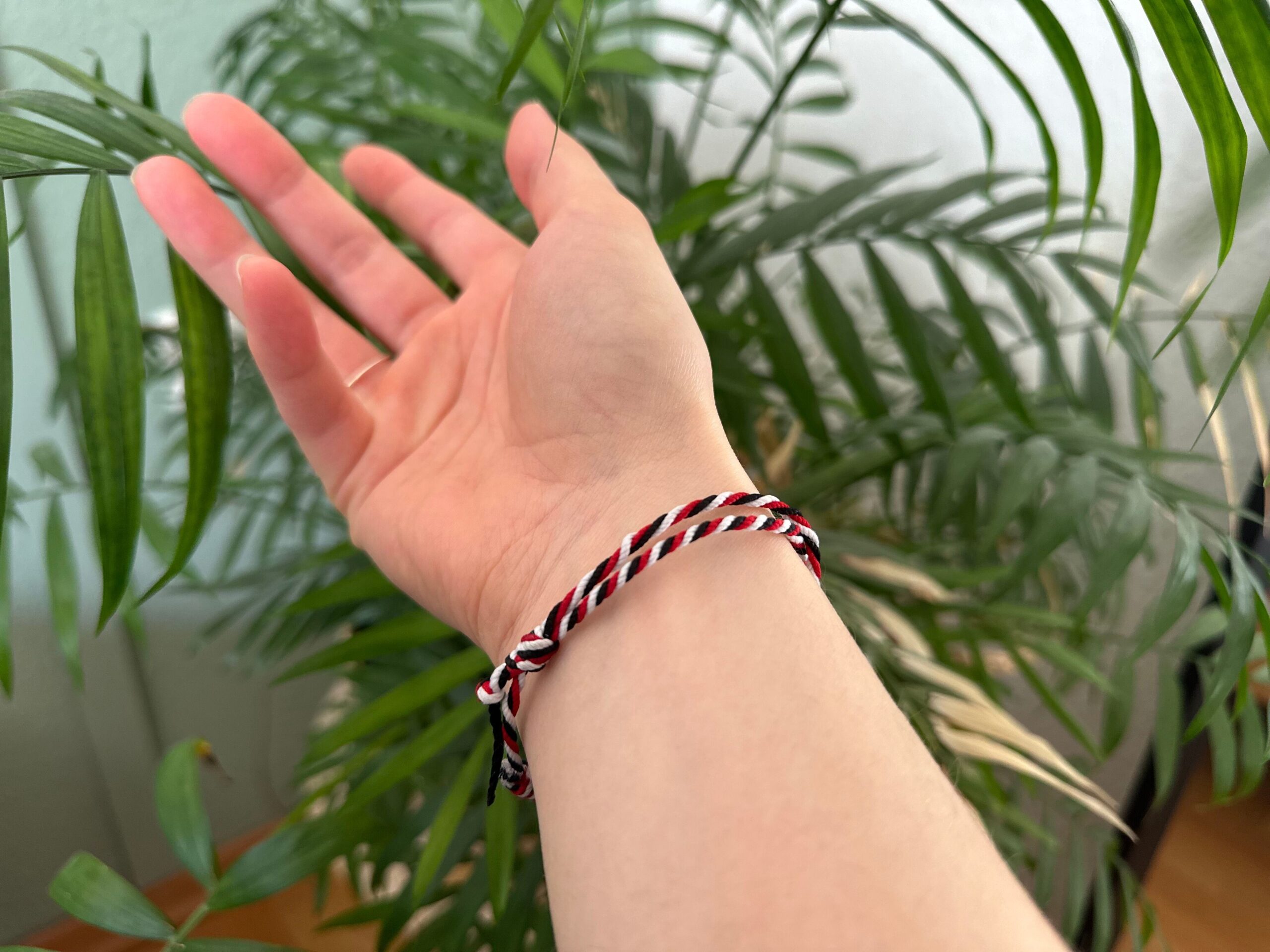 Tridatu Armband am Handgelenk einer Yogini